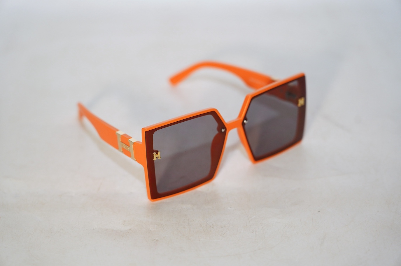 A pair of orange Hermes sunglasses